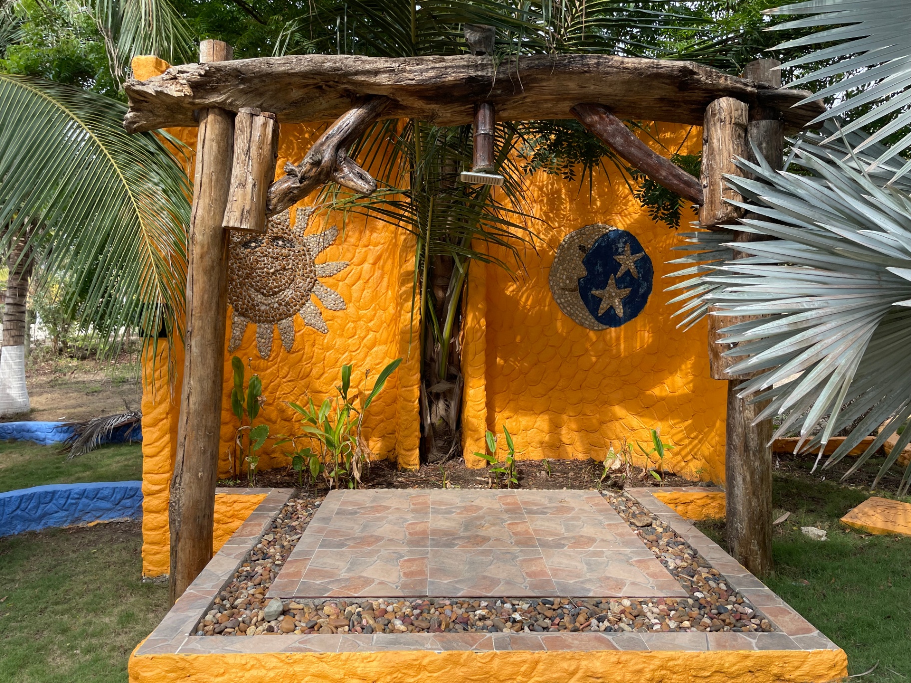 Handcrafted sun and moon mural in the tropical garden at Marahuaco Beach House Mural artesanal de sol y luna en el jardín tropical